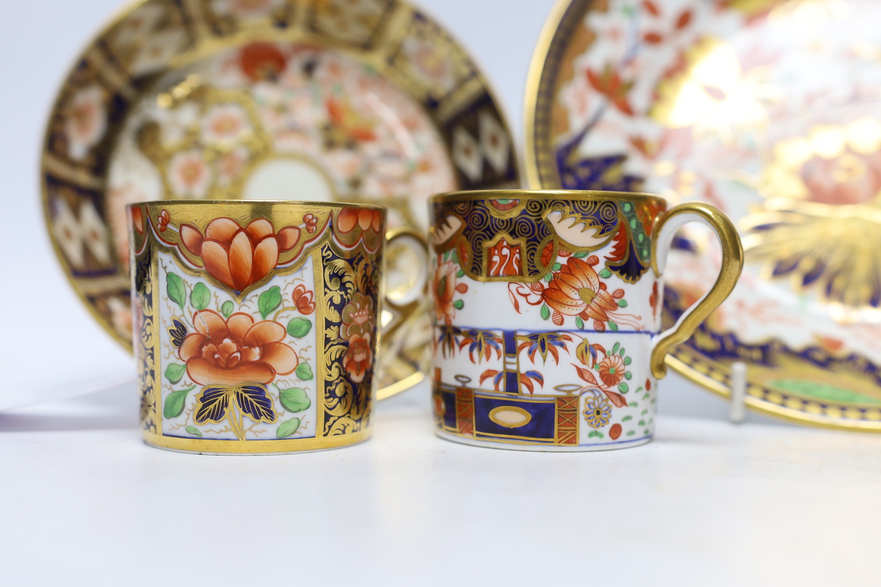 Ten 1800-1820 English porcelain coffee cans, including Imari pattern examples, one with matching saucer, together with a side plate (12)